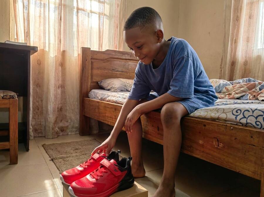 Boy discovering new Lastwell sneakers, smiling