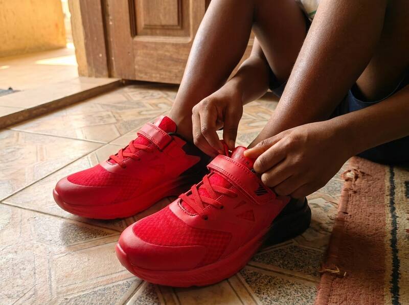 Child lacing up new SYSTEM sneakers